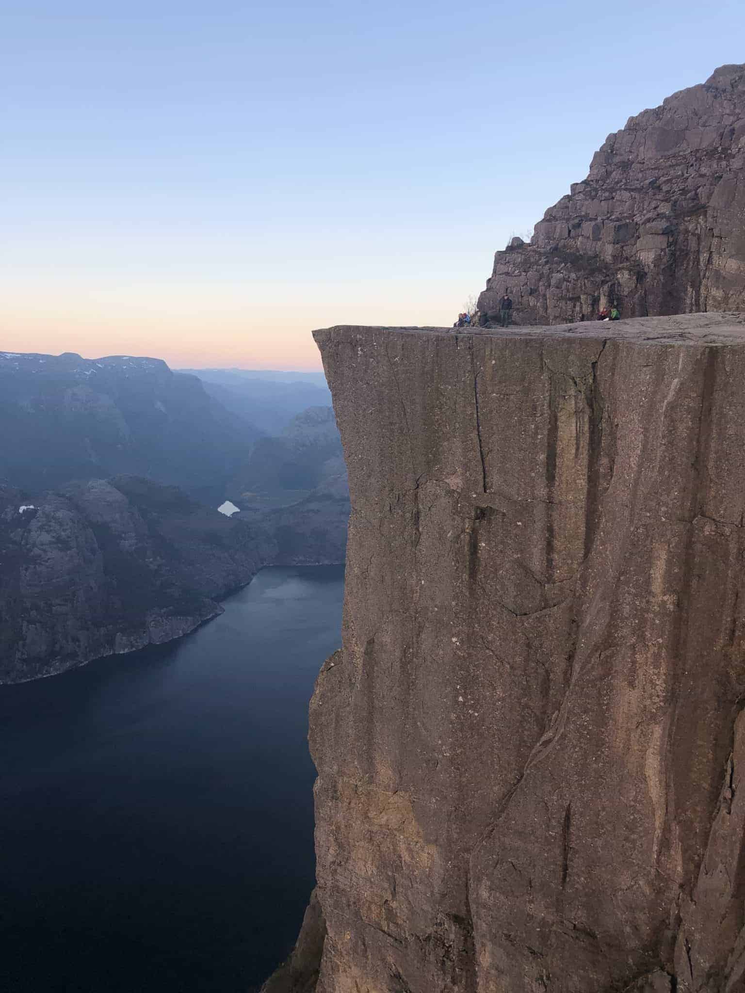 Vue à couper le souffle depuis Preikestolen, la célèbre falaise norvégienne surplombant le Lysefjord au coucher du soleil.